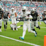 Nov 17, 2024; Miami Gardens, Florida, USA; Miami Dolphins running back De'Von Achane (28) scores a touchdown in the fourth quarter against the Las Vegas Raiders at Hard Rock Stadium.
