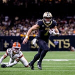 Nov 17, 2024; New Orleans, Louisiana, USA; New Orleans Saints tight end Taysom Hill (7) avoids the tackle of Cleveland Browns safety Ronnie Hickman (33) during the second half at Caesars Superdome.
