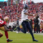 Nov 17, 2024; Santa Clara, California, USA; Seattle Seahawks quarterback Geno Smith (7) scores a rushing touchdown past San Francisco 49ers cornerback Isaac Yiadom (22) to win the game in the fourth quarter at Levi's Stadium. Mandatory Credit: David Gonzales-Imagn Images