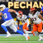 NFL: Cincinnati Bengals at Los Angeles Chargers. Nov 17, 2024; Inglewood, California, USA; Los Angeles Chargers quarterback Justin Herbert (10) runs the ball ahead of Cincinnati Bengals cornerback Mike Hilton (21) and defensive tackle Jay Tufele (97) during the first half at SoFi Stadium. Mandatory Credit: Gary A. Vasquez-Imagn Images