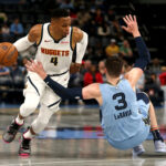 Nov 19, 2024; Memphis, Tennessee, USA; Denver Nuggets guard Russell Westbrook (4) drives to the basket as Memphis Grizzlies forward Jake LaRavia (3) falls during the first half at FedExForum.