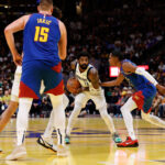 Nov 22, 2024; Denver, Colorado, USA; Dallas Mavericks guard Kyrie Irving (11) controls the ball against Denver Nuggets forward Peyton Watson (8) as center Dereck Lively II (2) and center Nikola Jokic (15) battle for position in the third quarter at Ball Arena. Mandatory Credit: Isaiah J. Downing-Imagn Images
