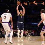 Nov 23, 2024; Los Angeles, California, USA; Denver Nuggets center Nikola Jokic (15) shoots a three-point shot against Los Angeles Lakers forward Anthony Davis (3) during the first quarter at Crypto.com Arena.
