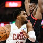 Nov 24, 2024; Cleveland, Ohio, USA; Cleveland Cavaliers guard Donovan Mitchell (45) drives to the basket against Toronto Raptors forward Jonathan Mogbo (2) during the first half at Rocket Mortgage FieldHouse. Mandatory Credit: Ken Blaze-Imagn Images