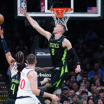 Nov 25, 2024; Boston, Massachusetts, USA; Boston Celtics center Kristaps Porzingis (8) defends against LA Clippers guard Amir Coffey (7) in the first quarter at TD Garden.
