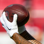 SANTA CLARA, CALIFORNIA - AUGUST 18: A detailed view of the Ronnie Bell #10 of the San Francisco 49ers wearing Nike gloves catching an official NFL football while warming up prior to the start of a preseason game against the New Orleans Saints at Levi's Stadium on August 18, 2024 in Santa Clara, California. (Photo by Thearon W. Henderson/Getty Images)