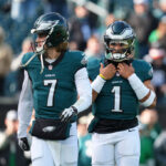 PHILADELPHIA, PENNSYLVANIA - DECEMBER 8: Kenny Pickett #7 and Jalen Hurts #1 of the Philadelphia Eagles look on prior to the game against the Carolina Panthers at Lincoln Financial Field on December 8, 2024 in Philadelphia, Pennsylvania. (Photo by Mitchell Leff/Getty Images)