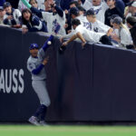 Oct 29, 2024; New York, New York, USA; Los Angeles Dodgers shortstop Mookie Betts (50) makes a catch in foul territory as a New York Yankees fan interferes during the first inning in game four of the 2024 MLB World Series at Yankee Stadium. Mandatory Credit: Brad Penner-Imagn Images