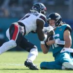 Dec 1, 2024; Jacksonville, Florida, USA; Jacksonville Jaguars quarterback Trevor Lawrence (16) slides down in front of Houston Texans linebacker Azeez Al-Shaair (0) in the second quarter in the second quarter at EverBank Stadium. Mandatory Credit: Nathan Ray Seebeck-Imagn Images