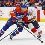 Dec 16, 2024; Edmonton, Alberta, CAN; Florida Panthers defensemen Dmitry Kulikov (7) tries to tie up Edmonton Oilers forward Connor McDavid (97) during the third period at Rogers Place. Mandatory Credit: Perry Nelson-Imagn Images