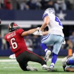 Dec 22, 2024; Arlington, Texas, USA; Tampa Bay Buccaneers quarterback Baker Mayfield (6) fumbles the ball after being hit by Dallas Cowboys linebacker Nick Vigil (41) in the second half at AT&T Stadium. Mandatory Credit: Tim Heitman-Imagn Images