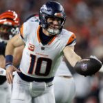 Dec 28, 2024; Cincinnati, Ohio, USA; Denver Broncos quarterback Bo Nix (10) hands off the ball against the Cincinnati Bengals during the second quarter at Paycor Stadium.