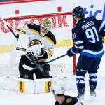 Boston Bruins goalie Jeremy Swayman (1) makes a save as Winnipeg Jets forward Cole Perfetti (91) looks for a rebound during the third period at Canada Life Centre.