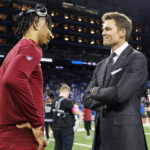 DETROIT, MICHIGAN - JANUARY 18: Quarterback Jayden Daniels #5 of the Washington Commanders interacts with Fox Sports commentator Tom Brady prior to an NFL football divisional playoff game against the Detroit Lions, at Ford Field on January 18, 2025 in Detroit, Michigan. (Photo by Brooke Sutton/Getty Images)