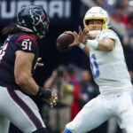Oct 2, 2022; Houston, Texas, USA; NFL; Los Angeles Chargers quarterback Justin Herbert (10) throws past Houston Texans defensive tackle Roy Lopez (91) during the second quarter at NRG Stadium.