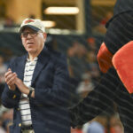Jun 28, 2024; Baltimore, Maryland, USA; Baltimore Orioles owner David Rubenstein stands with Bird on top of the dugout during the seventh inning stretch against the Texas Rangers at Oriole Park at Camden Yards. Mandatory Credit: Tommy Gilligan-USA TODAY Sports - Baltimore Orioles