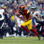 Dec 22, 2024; Landover, Maryland, USA; Washington Commanders quarterback Jayden Daniels (5) runs the ball against Philadelphia Eagles linebacker Zack Baun (53) during the fourth quarter at Northwest Stadium. Mandatory Credit: Peter Casey-Imagn Images