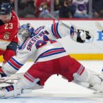 Dec 30, 2024; Sunrise, Florida, USA; New York Rangers goaltender Igor Shesterkin (31) pins the puck against the post as Florida Panthers center Carter Verhaeghe (23) closes in during the second period at Amerant Bank Arena. Mandatory Credit: Jim Rassol-Imagn Images