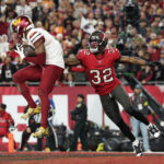Jan 12, 2025; Tampa, Florida, USA; Washington Commanders wide receiver Terry McLaurin (17) catches a touchdown against Tampa Bay Buccaneers safety Josh Hayes (32) during the fourth quarter of a NFC wild card playoff at Raymond James Stadium. Mandatory Credit: Nathan Ray Seebeck-Imagn Images
