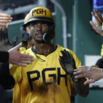 Aug 16, 2024; Pittsburgh, Pennsylvania, USA; Pittsburgh Pirates center fielder Michael A. Taylor (18) high-fives in the dugout after scoring a run against the Seattle Mariners during the seventh inning at PNC Park. Mandatory Credit: Charles LeClaire-USA TODAY Sports