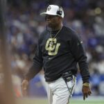 Dec 28, 2024; San Antonio, TX, USA; Colorado Buffaloes head coach Deion Sanders walks on the field during the game against the Brigham Young Cougars at Alamodome. Mandatory Credit: Troy Taormina-Imagn Images