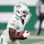 Jan 5, 2025; East Rutherford, New Jersey, USA; Miami Dolphins wide receiver Tyreek Hill (10) returns punt during the first half against the New York Jets at MetLife Stadium. Mandatory Credit: Vincent Carchietta-Imagn Images
