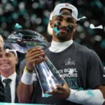 Feb 9, 2025; New Orleans, LA, USA; Philadelphia Eagles quarterback Jalen Hurts holds the Lombardi Trophy during the championship trophy presentation after the Eagles' game against the Kansas City Chiefs in Super Bowl LIX at Caesars Superdome.