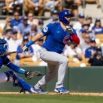 Feb 20, 2025; Phoenix, Arizona, USA; Chicago Cubs catcher Reese McGuire hits a two run double against the Los Angeles Dodgers during a spring training game at Camelback Ranch-Glendale.