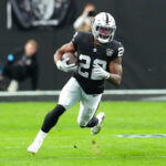 Jan 5, 2025; Paradise, Nevada, USA; Las Vegas Raiders running back Alexander Mattison (22) gains yardage against the Los Angeles Chargers during the first quarter at Allegiant Stadium. Mandatory Credit: Stephen R. Sylvanie-Imagn Images