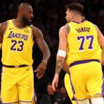 Feb 27, 2025; Los Angeles, California, USA; Los Angeles Lakers forward LeBron James (23) and guard Luka Doncic (77) react after a play during the first quarter against the Minnesota Timberwolves at Crypto.com Arena.