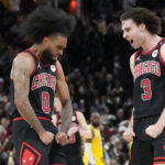 Mar 27, 2025; Chicago, Illinois, USA; Chicago Bulls guard Coby White (0) celebrates his three point basket against the Los Angeles Lakers with guard Josh Giddey (3) during the second half at United Center.