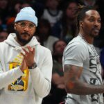 Apr 10, 2022; Denver, Colorado, USA; Los Angeles Lakers forward Carmelo Anthony (7) (left) and center Dwight Howard (39) (right) cheer during the second half against the Denver Nuggets at Ball Arena.