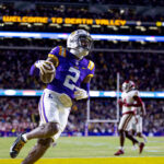 Nov 30, 2024; Baton Rouge, Louisiana, USA; LSU Tigers wide receiver Kyren Lacy (2) runs after a catch and scores a touchdown against Oklahoma Sooners defensive back Billy Bowman Jr. (2) during the first quarter at Tiger Stadium. Mandatory Credit: Stephen Lew-Imagn Images
