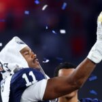 Dec 31, 2024; Glendale, AZ, USA; Penn State Nittany Lions defensive end Abdul Carter (11) reacts with the trophy after the game against the Boise State Broncos in the Fiesta Bowl at State Farm Stadium. Mandatory Credit: Mark J. Rebilas-Imagn Images