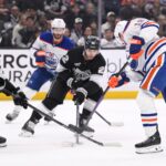 NHL Playoffs 2025 foto - Apr 5, 2025; Los Angeles, California, USA; Los Angeles Kings defenseman Mikey Anderson (44) and left wing Kevin Fiala (22) converge on Edmonton Oilers left wing Zach Hyman (18) during the first period at Crypto.com Arena. Mandatory Credit: Robert Hanashiro-Imagn Images