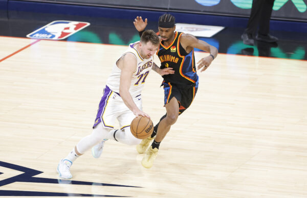 Apr 6, 2025; Oklahoma City, Oklahoma, USA; Los Angeles Lakers guard Luka Doncic (77) drives down the court beside Oklahoma City Thunder guard Shai Gilgeous-Alexander (2) during the second half at Paycom Center.
