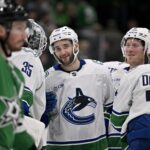 Apr 8, 2025; Dallas, Texas, USA; Vancouver Canucks goaltender Thatcher Demko (35) and center Max Sasson (63) and right wing Brock Boeser (6) and left wing Jake DeBrusk (74) celebrate the victory over the Dallas Stars at the American Airlines Center. Mandatory Credit: Jerome Miron-Imagn Images