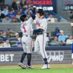 Apr 14, 2025; Toronto, Ontario, CAN; Atlanta Braves third baseman Austin Riley (27) hits a three run home run and celebrates with second baseman Ozzie Albies (1) against the Toronto Blue Jays during the fifth inning at Rogers Centre. Mandatory Credit: Nick Turchiaro-Imagn Images
