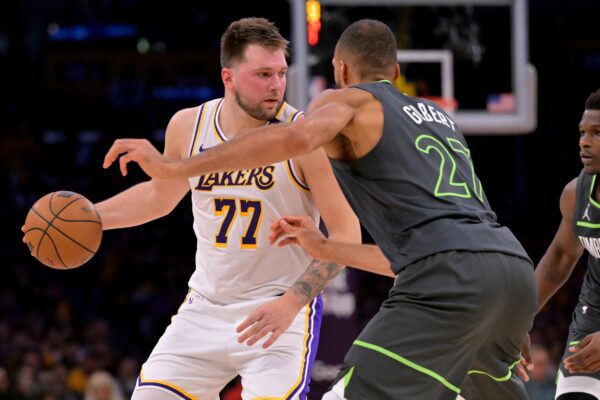 Lakers Jogo 2 - Apr 19, 2025; Los Angeles, California, USA; Los Angeles Lakers guard Luka Doncic (77) is defended by Minnesota Timberwolves center Rudy Gobert (27) in the first half at Crypto.com Arena.