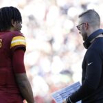 Nov 24, 2024; Landover, Maryland, USA; Washington Commanders quarterback Jayden Daniels (5) talks with Commanders offensive coordinator Kliff Kingsbury (R) during a timeout Dallas Cowboys during the second quarter at Northwest Stadium.