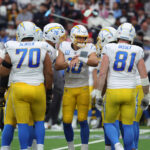 Jan 11, 2025; Houston, Texas, USA; Los Angeles Chargers quarterback Justin Herbert (10) in a huddle during the first quarter against the Houston Texans in an AFC wild card game at NRG Stadium. Mandatory Credit: Troy Taormina-Imagn Images