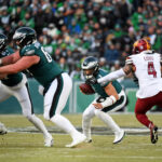 Jan 26, 2025; Philadelphia, PA, USA; Philadelphia Eagles quarterback Jalen Hurts (1) runs with the ball against Washington Commanders linebacker Frankie Luvu (4) during the first half in the NFC Championship game at Lincoln Financial Field. Mandatory Credit: Eric Hartline-Imagn Images