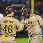 May 5, 2025; Bronx, New York, USA; San Diego Padres catcher Elias Díaz (17) is greeted at first by first base coach David Macias (46) after hitting a single against the New York Yankees during the third inning at Yankee Stadium. Mandatory Credit: John Jones-Imagn Images