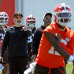 Cleveland Browns coach Kevin Stefanski watches quarterback Shedeur Sanders (12) participate in drills during day two of NFL rookie minicamp at the Cleveland Browns training facility May 10, 2025, in Berea, Ohio.