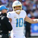Nov 3, 2024; Cleveland, Ohio, USA; Los Angeles Chargers quarterback Justin Herbert (10) talks to head coach Jim Harbaugh during the first quarter against the Cleveland Browns at Huntington Bank Field. Mandatory Credit: Ken Blaze-Imagn Images