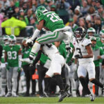 Nov 3, 2024; Philadelphia, Pennsylvania, USA; Philadelphia Eagles running back Saquon Barkley (26) jumps over Jacksonville Jaguars cornerback Jarrian Jones (22) during the second quarter at Lincoln Financial Field. Mandatory Credit: Eric Hartline-Imagn Images
