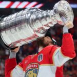 Jun 17, 2025; Sunrise, Florida, USA; Florida Panthers center Sam Reinhart (13) hoists the Stanley Cup after winning game six of the 2025 Stanley Cup Final against the Edmonton Oilers at Amerant Bank Arena. Mandatory Credit: Sam Navarro-Imagn Images