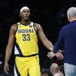 Mar 20, 2023; Charlotte, North Carolina, USA; Indiana Pacers center Myles Turner (33) slaps hands with Indiana Pacers head coach Rick Carlisle as he goes to the bench during the first half against the Charlotte Hornets at Spectrum Center.