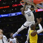 Apr 28, 2023; Los Angeles, California, USA; Memphis Grizzlies guard Ja Morant (12) hangs on the rim to avoid landing on Los Angeles Lakers forward LeBron James (6) after a dunk in the first quarter of game six of the 2023 NBA playoffs at Crypto.com Arena. Mandatory Credit: Jayne Kamin-Oncea-USA TODAY Sports