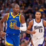 Oct 9, 2024; Sacramento, California, USA; Golden State Warriors forward Jonathan Kuminga (00) and Sacramento Kings forward Keegan Murray (13) jog up the court during the first quarter at Golden 1 Center.
